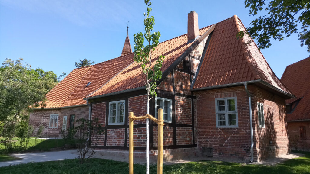 Saniertes Herrenpfründerhaus am Nikolaihof Bardowick mit rotem Walmdach, Backstein- und Fachwerkfassade, denkmalgerecht instandgesetzt für zeitgemäßes Wohnen.