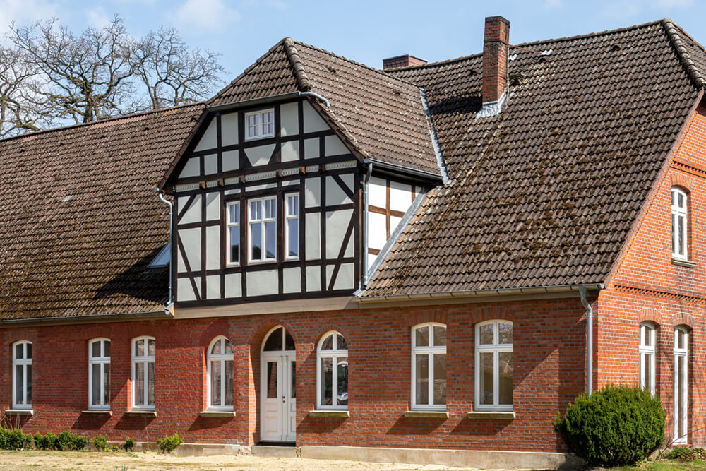 Seitliche Ansicht eines renovierten alten Fachwerkhauses bei schönem Wetter.